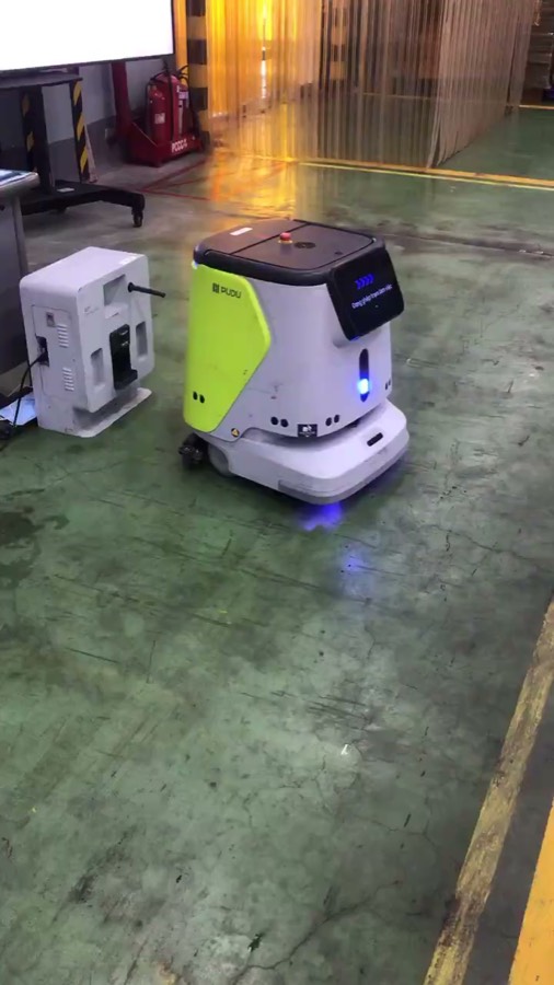Robot CC1 tại trạm sạc cạnh rèm nhựa vàng ngăn khu vực