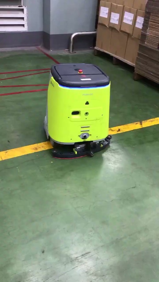 Robot CC1 chà sàn ở khu vực trống trải giữa lối đi có vạch kẻ vàng