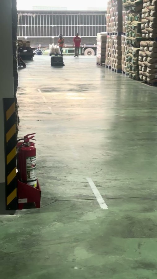 Toàn cảnh kho với công nhân và xe tải đang xuất hàng